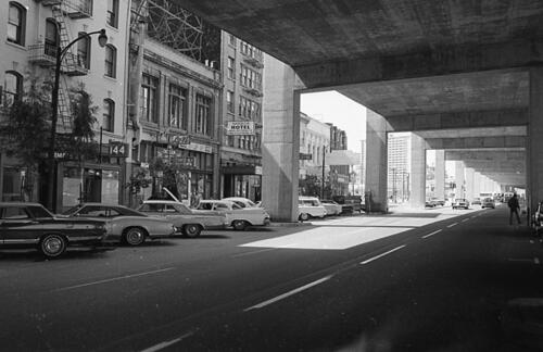 [Hotels and businesses on the 100 block of Embarcadero as seen from under the Embarcadero Freeway]