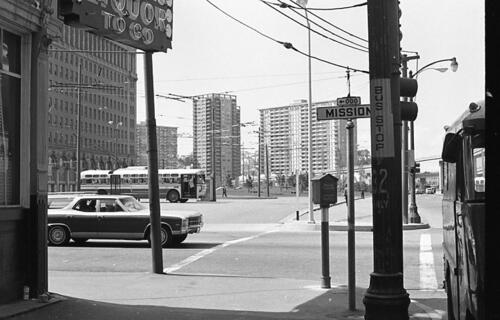 [Corner of Mission and Embarcadero looking north, view of bus stops, plaza, and apartment towers]