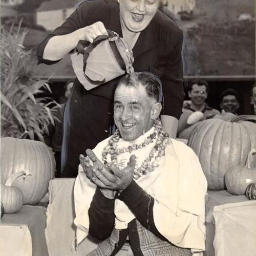 [Evelyn La Place pouring orange juice over the head of Earl Jordan at the Farmers' Market on Alemany Boulevard]