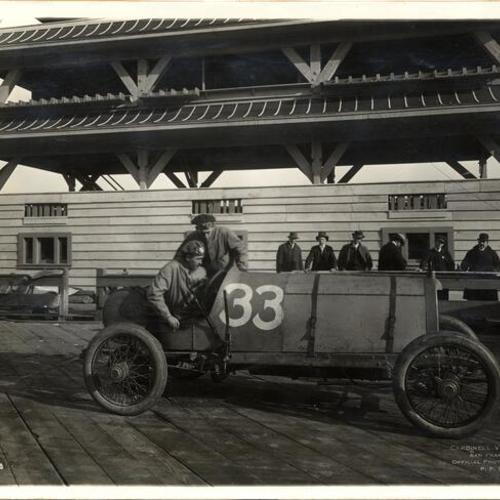 [Roy Francis sitting behind the wheel of a race car at the Panama-Pacific International Exposition]