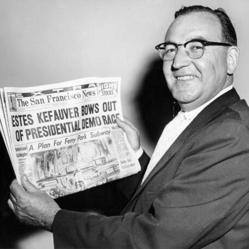 [California Attorney General Edmund G. (Pat) Brown holds up a news headline announcing the withdrawal of Senator Estes Kefauver from the presidential race]