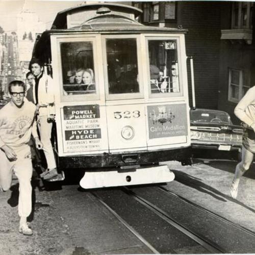 [John Sweet and Rich League running next to a Powell and Hyde streets line cable car]
