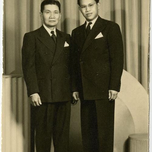 [Braulio and his cousin pose in suits at a photo studio]