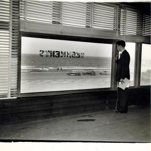 [Unidentified man looking out the window of the Beach Chalet at Ocean Beach]