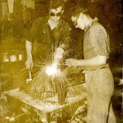 [Two students learning electric arc welding at Samuel Gompers School]
