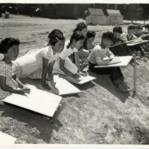 [Group of Japanese children drawing outdoors inside "Little Tokyo"]