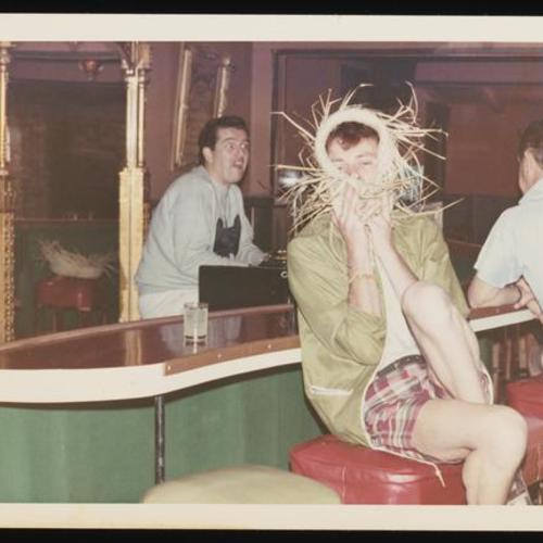 Person with straw hat sitting at bar