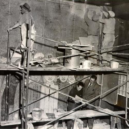 [Artist Beniamino Bufano and Ted Wetteland inspecting a mosaic mural being created by Bufano]