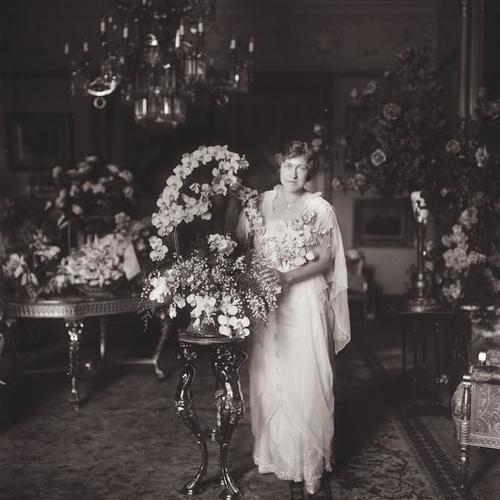 Person standing with floral arrangements in Victorian home