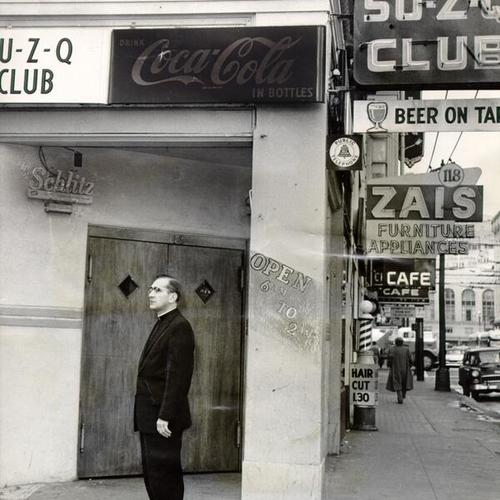 [Rev. Avery Heisey standing in front of the Su-Z-Q Club at Fourth and Minna streets]
