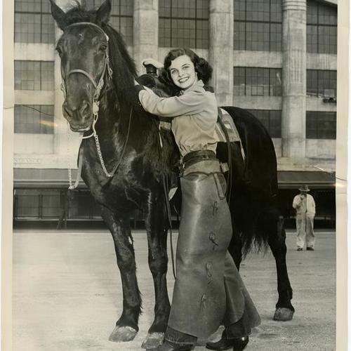[Dianne Goldman, junior at Sacred Heart Convent, riding with the drill team at St. Francis Riding Academy]