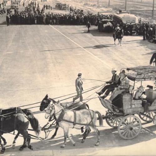 [Wagon team, "Strangest race" participant, passing by spectators in the opening day celebration parade for San Francisco-Oakland Bay Bridge]