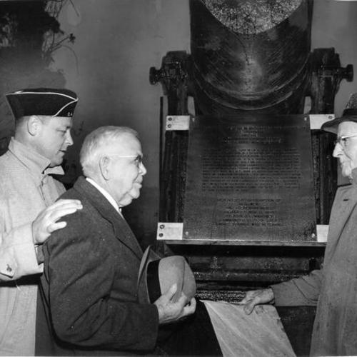[Gene McAteer, John J. F. Mahoney and Fred Baldwin standing next to Krupp cannon at rededication ceremony in Columbia Square]