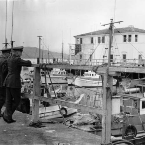 [Sergeant William Barker and Sergeant Ray Walker leaning against a pier at Fisherman's Wharf]