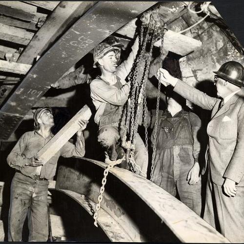[Workmen working inside Yerba Buena Island tunnel during San Francisco-Oakland Bay Bridge construction]