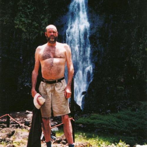 [Man posing in front of waterfall in Tahiti]