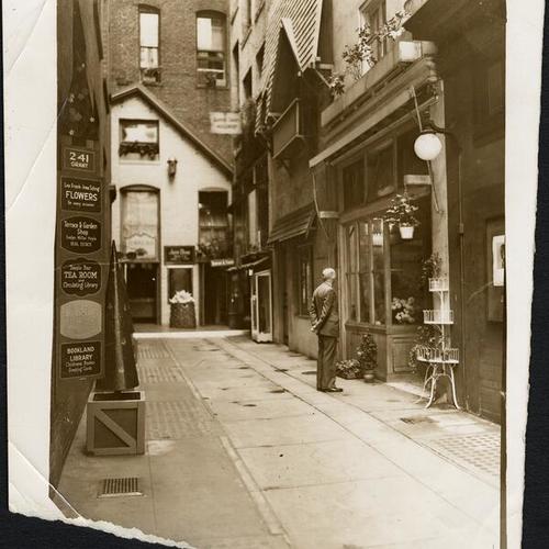 [Man standing in front of a store on Tillman Place]