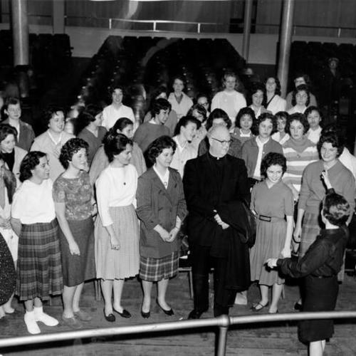 [Father Alfred Boeddeker with the Notre Dame des Victories Glee Club preparing for the Calvacade of a Century Presentation]