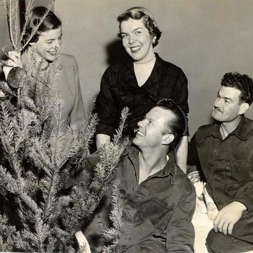 [Macy's employees Joan Otten and Mary Cochran delivering Christmas trees to veterans at Fort Miley Hospital]