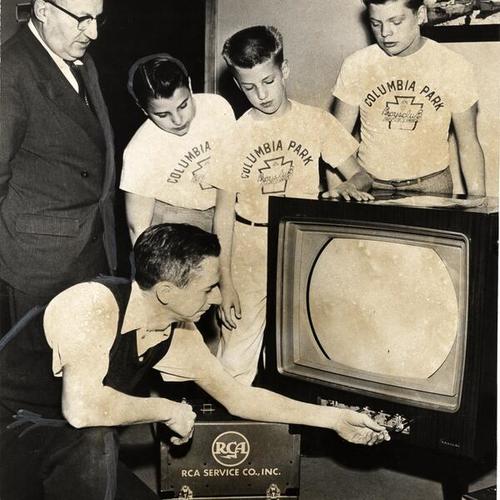 [Columbia Park Boys Club director J.P. Hargrove with members Dan Ortner, James Mills and Larry Close observe Louis Weitlauf while adjusting their new color TV set]