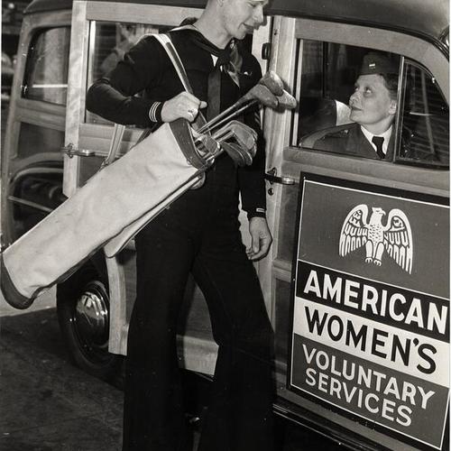 [Volunteer of the American Women's Voluntary Services (AWVS) gives a ride to a service man]