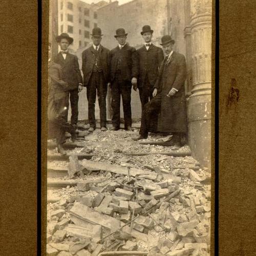 [Several men standing amidst the ruins of the Postal Telegraph]