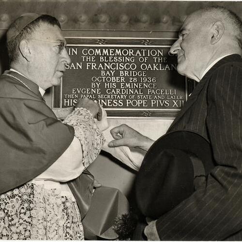 [Archbishop John J. Mitty dedicates plaque on Bay Bridge commemorating tenth anniversary of original  bridge blessing while acting San Francisco mayor Jesse Colman looks on]
