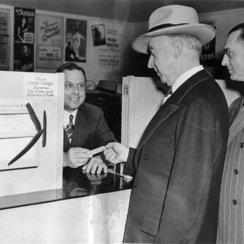 [Louis Chess (left) sells ticket to Thomas A. Brooks, S.F. Chief Administrative Officer]