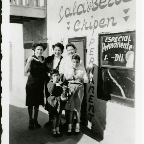 [Two children and three women in front of a beauty salon in Tijuana, Mexico]