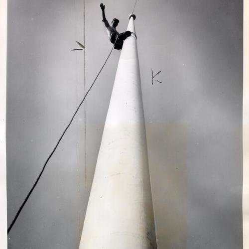 [Steeplejack James Phelan climbing a flagpole near Farmers' Market on Alemany Boulevard]