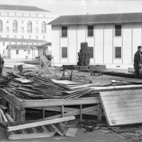 [Workmen tearing down temporary barracks constructed on the Civic Center Plaza]