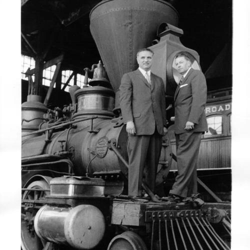 [Mayor George Christopher and Gilbert Kneiss posing in front of an historic train]