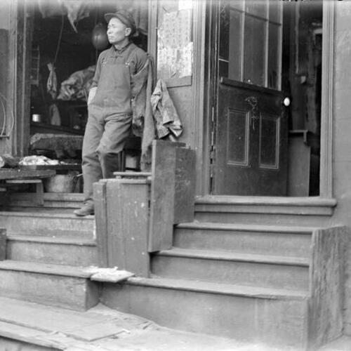 [Fish market; clerk standing on stairs, hanging scales]