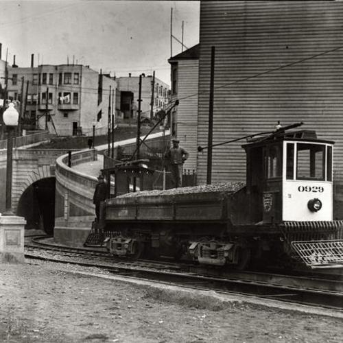 [West Portal Sunset Tunnel showing Market Street Railway Differential Dump car 0929 delivering ballast in final stages of construction]