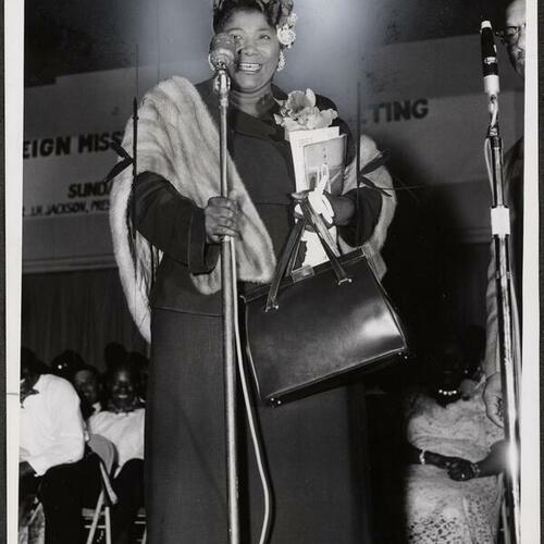 Mahalia Jackson holding microphone at National Baptist Convention in Civic Auditorium