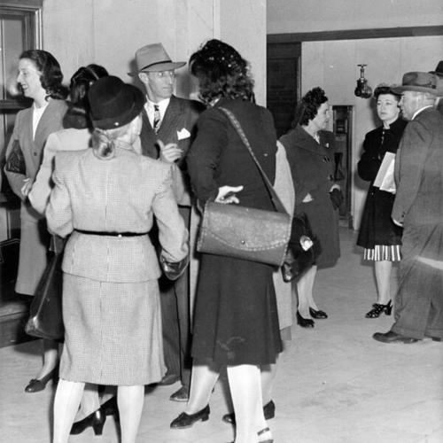 [Harry Bridges, chatting with some women in the court corridor at San Francisco, at the hearing of his divorce suit]