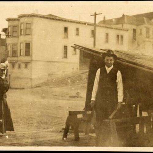 [Man and woman standing next to a street kitchen.]