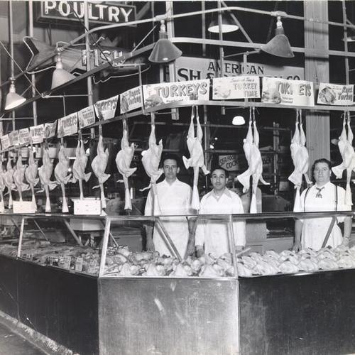 [Three butchers standing behind the counter of the poultry department at the Crystal Palace Market]
