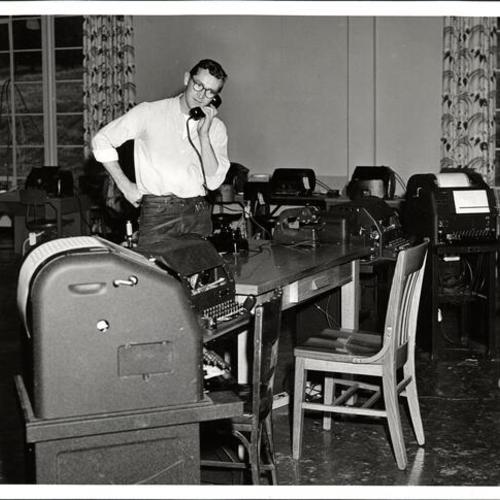 [Pacific Telephone and Telegraph employee Ray Tiles checking equipment in the library of the Presidio Service Club, press room for media covering the signing of the Security Treaty between the United States and Japan]