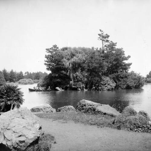 [Three men in a rowboat on Stow Lake in Golden Gate Park]