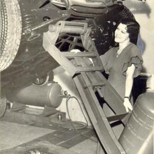 [Miss Emily Smith demonstrating a new car jack at an auto show in San Francisco Civic Auditorium]