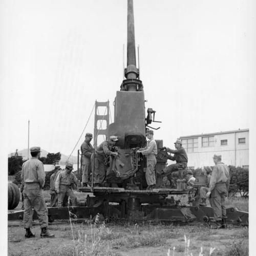 [Soldiers cleaning a 120mm anti-aircraft gun at the Presidio]
