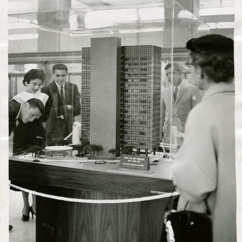 [Men and women look at an architectural model of the Crown Zellerbach Building]