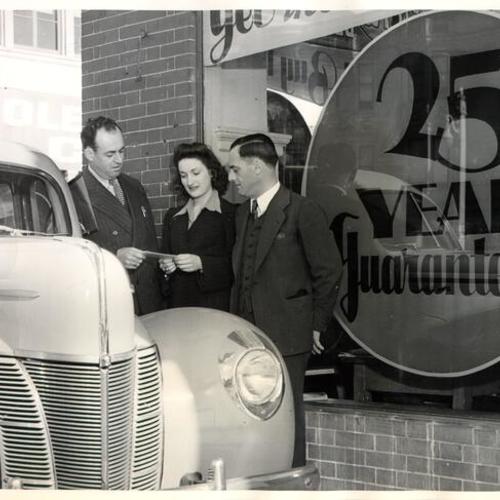 [Maggini Motor Car Company officials Walt Jacks and Babe Maggini talking to customer Mary Cerutti]