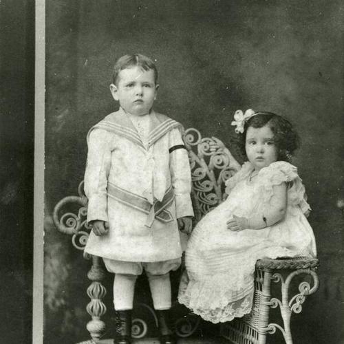 [Emett and his sister Aileen dressed up and posing for a studio photo]