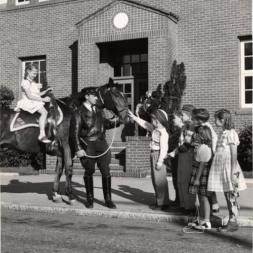 [Kids petting a policeman's horse]