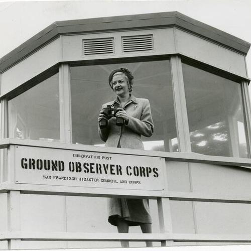 [Pauline Gale holds binoculars on deck of the Ground Observer Corps observation post at Fort Miley ]