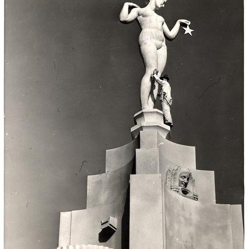 [Workman swabbing down the statue 'Evening Star' by sculptor Ettore Cadorin in the Court of the Moon, Golden Gate International Exposition on Treasure Island]
