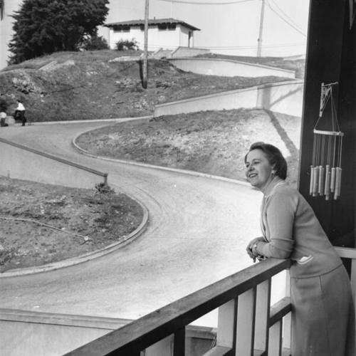 [Mrs. George Stetson, of 897 Vermont Street, at Kansas, looking from the balcony of her home onto crooked Vermont Street]
