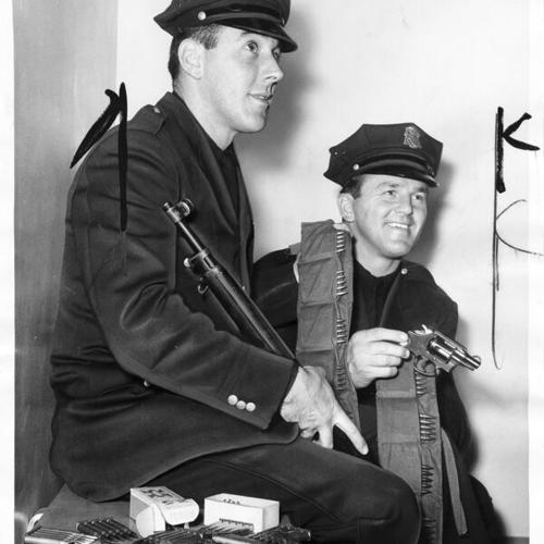 [Officers John Wydler and Paul Schneider displaying one man's arsenal]